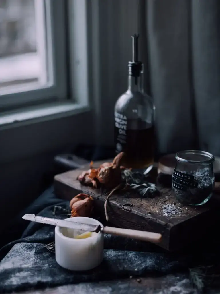 A dark image with a bowl of olive oil and butter