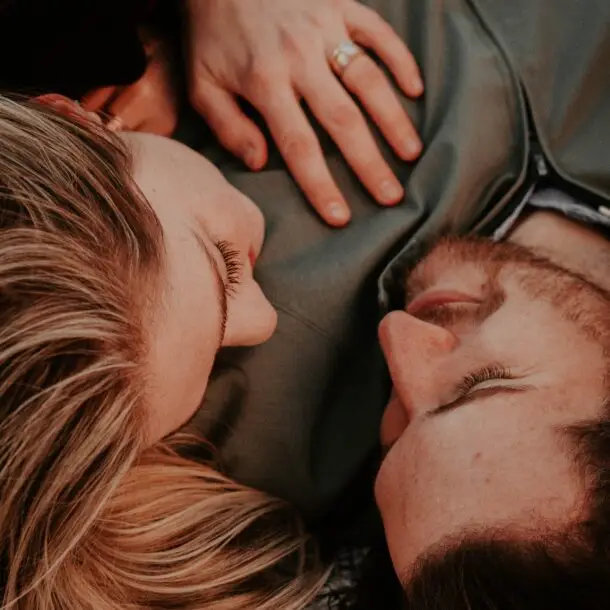 A woman and a man laying on the ground.