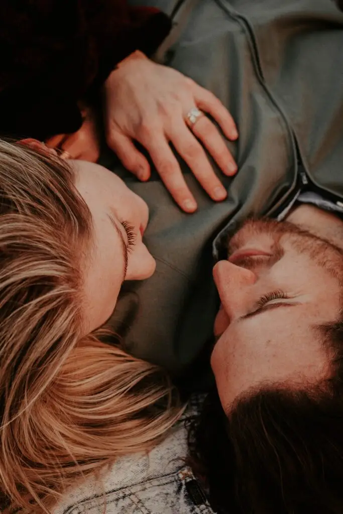 A woman and a man laying on the ground.
