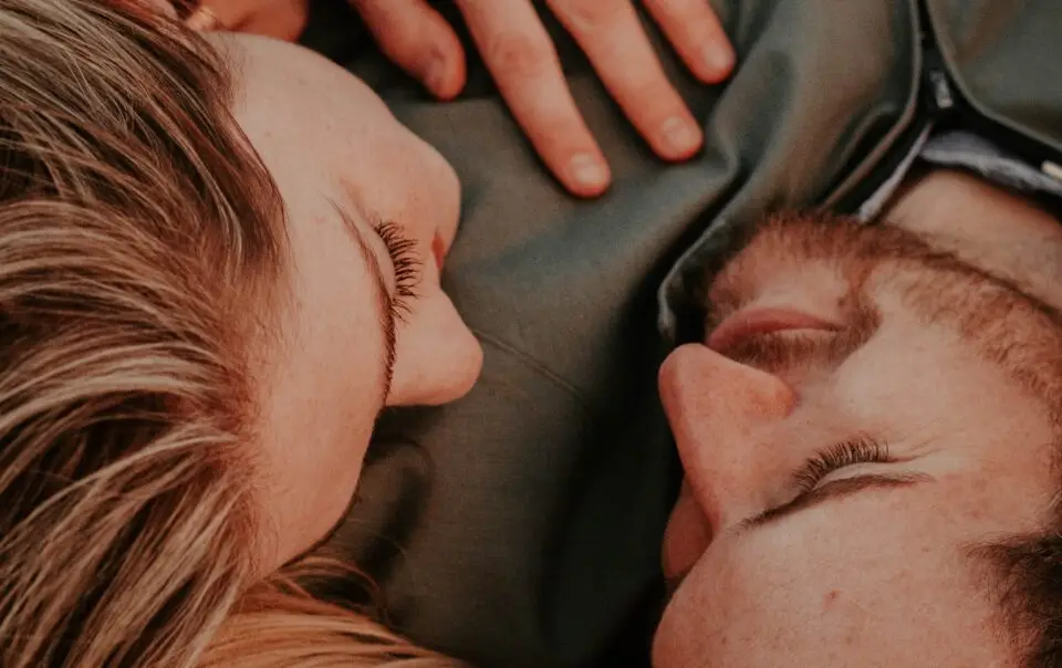 A woman and a man laying on the ground.