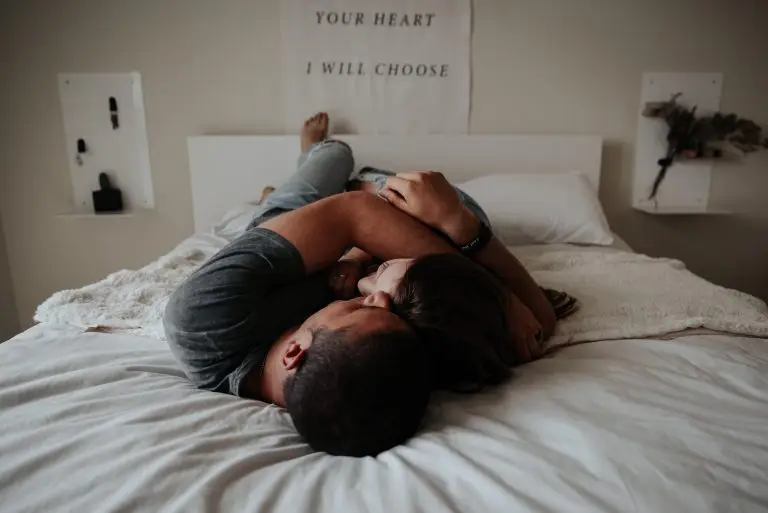 A woman and a man laying on the bed together