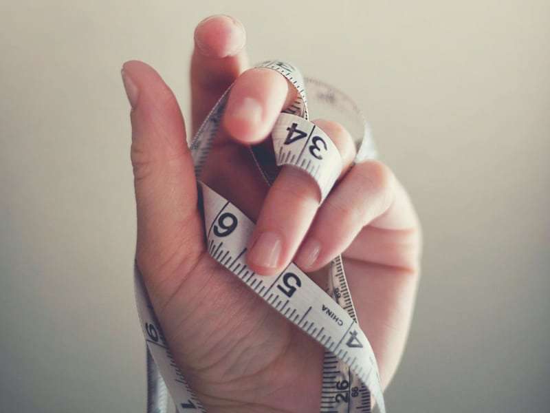 how to lose weight with hypothyroidismclose up of measuring tape wrapped around a hand