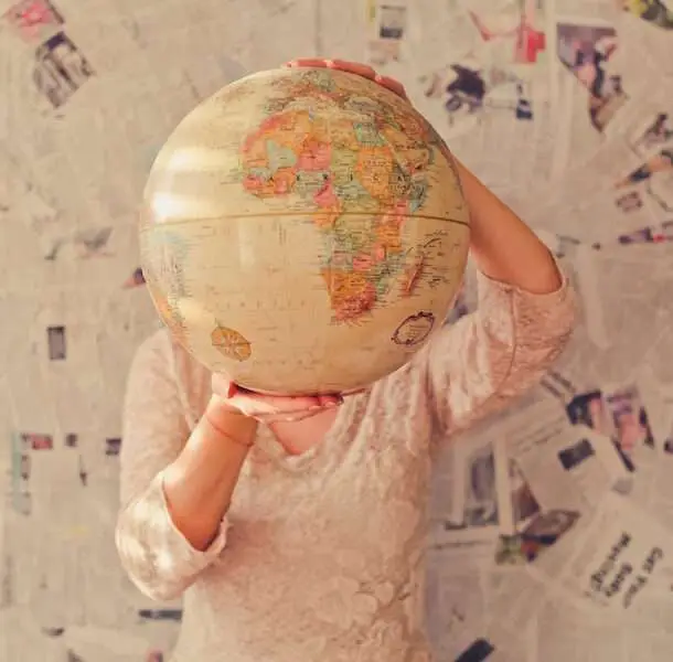 Fertility Boosting Diet Tips That Work No Matter Where You Live -- woman holding globe in front of face