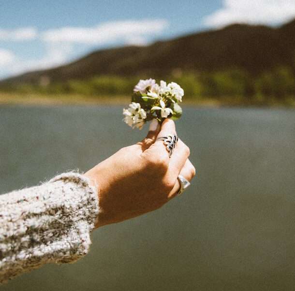 benefits of cbd oil for women, image of hand holding wildflower