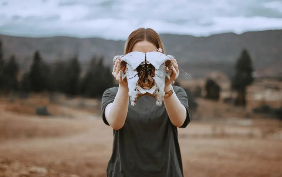 A woman holding a cow skull
