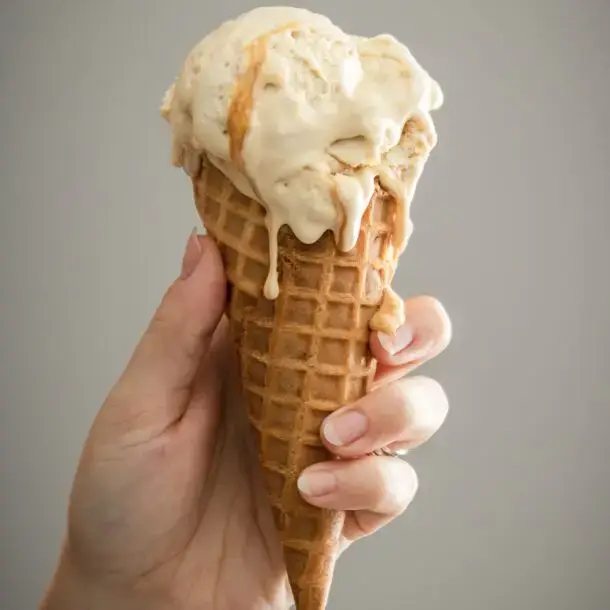 A person holding a vanilla ice cream.