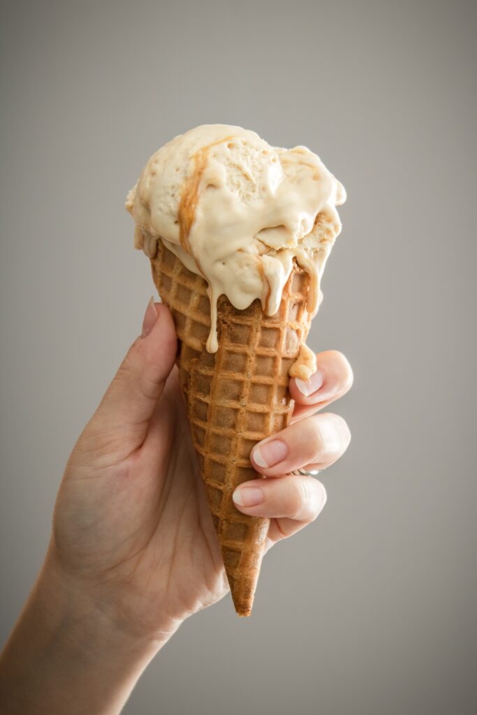 A person holding a vanilla ice cream.