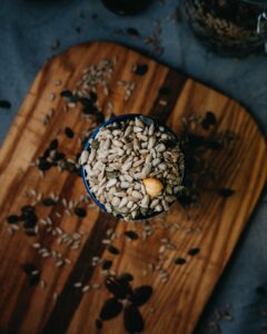 An image of nuts in a bowl on a wood cutting board.