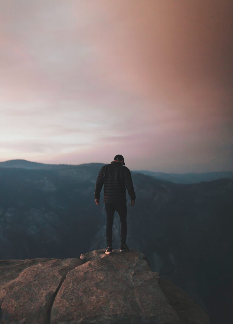 A man hiking at sunset standing on a mountain